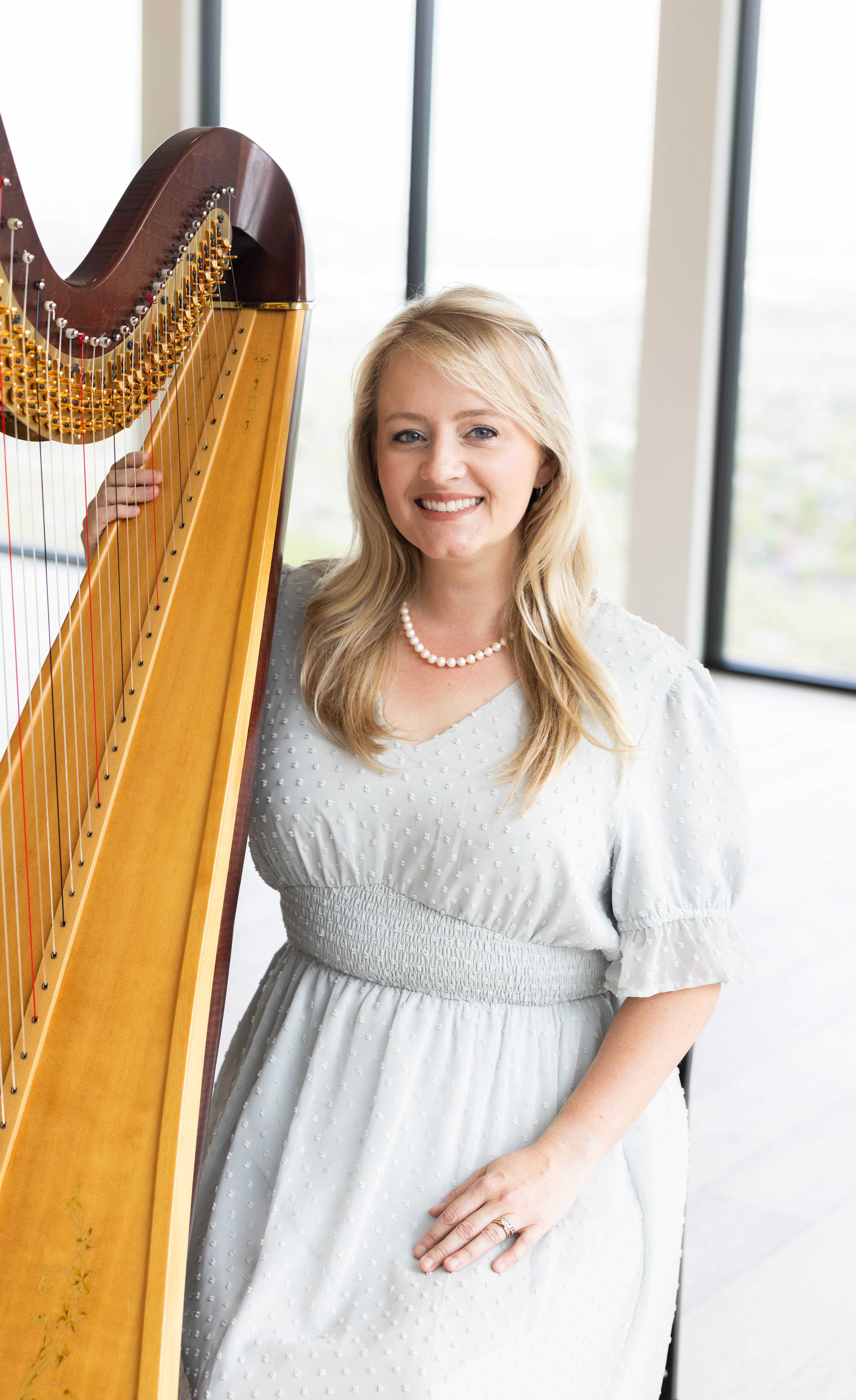 Portrait of harpist Laura Neil with her pedal harp